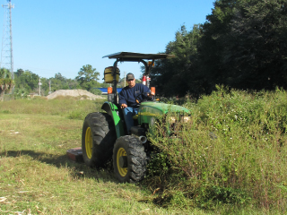 Man in tractor clearing brush