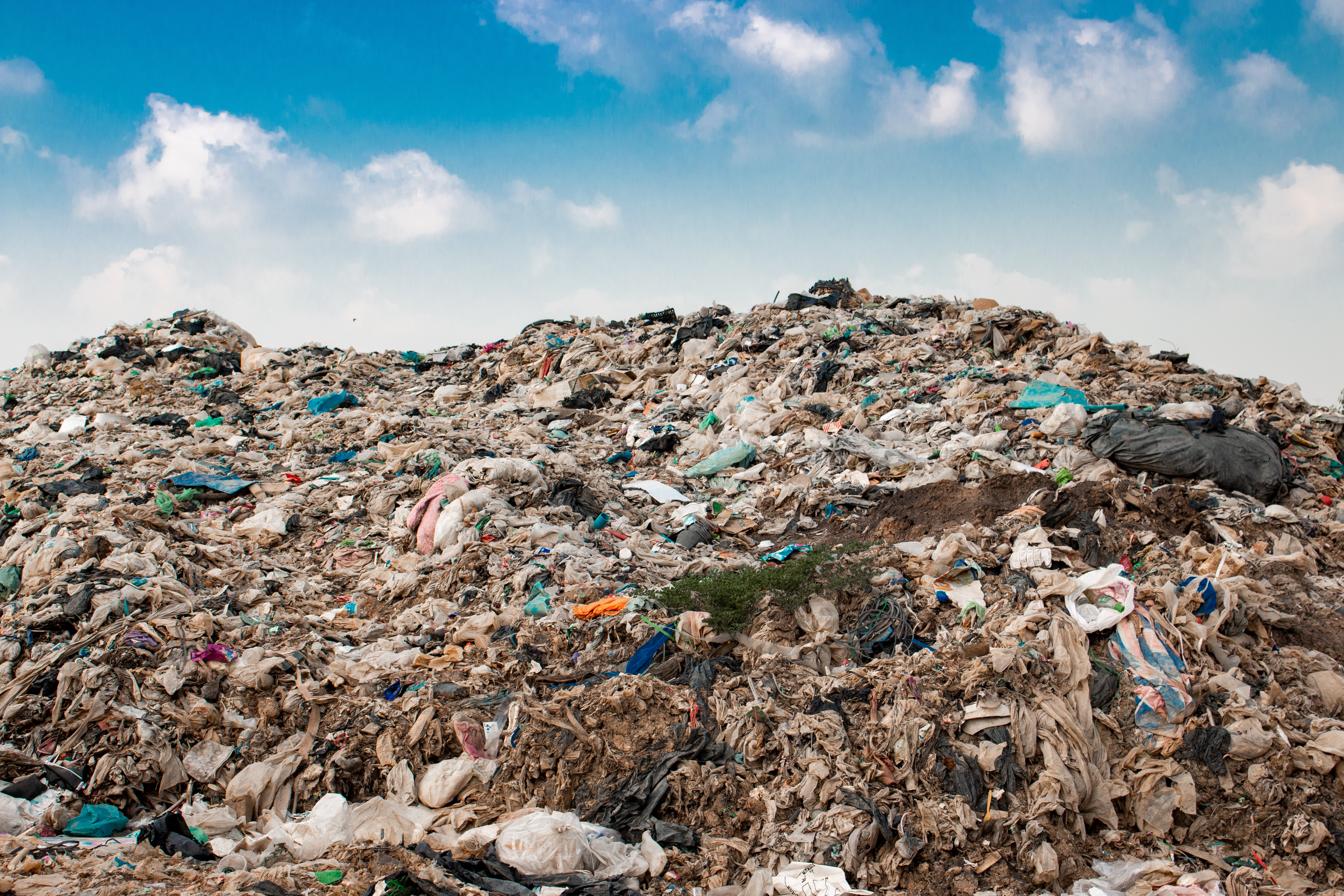landfill trash with blue sky and clouds