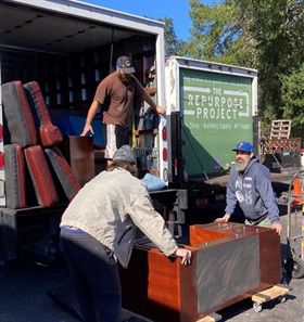 three men loading furniture into a donation truck